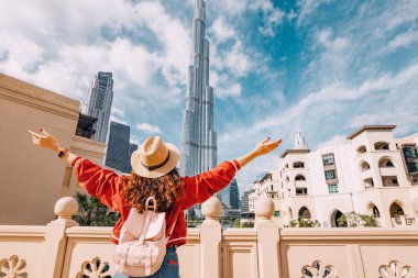 Dubai, BAE 'deki gerçek dışı Burj Halife kulesiyle inanılmaz manzarayı kucakladığı için mutlu kız kolları açılır.