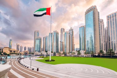 Gökdelen binaları ve ulusal bayrağıyla Dubai gökdeleninin manzarası. Arap Emirlikleri 'ni gezmek ve gezmek.