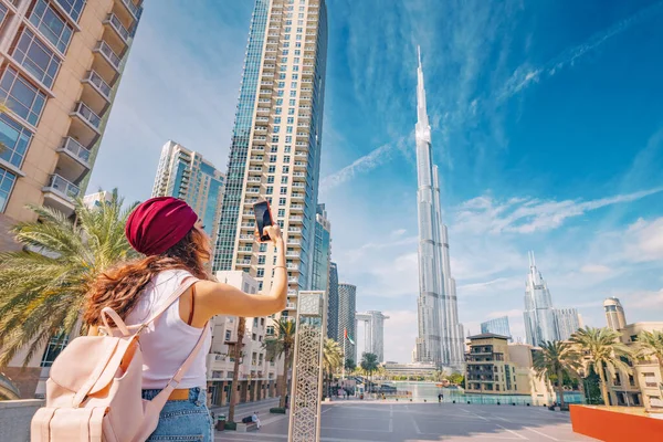 幸せな観光アジアの女の子彼女の旅行ブログのために写真を撮る ドバイのダウンタウン地区壮大なブルジュ ハリファ世界で最も高い超高層ビルを背景に — ストック写真