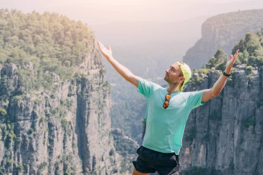 Türkiye 'deki Tazi Kanyonu' nun tepesinde duran mutlu gezgin. Turistik yerler ve gökyüzü konsepti