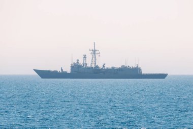 Açık denizde ufukta bir askeri savaş gemisi var.