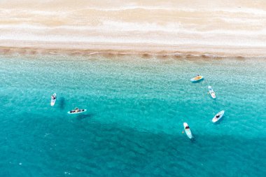 Türkiye 'de deniz kenarında yüzen pansiyonerlerin bulunduğu bir plaj manzarası. Cennet ve tatil beldesi