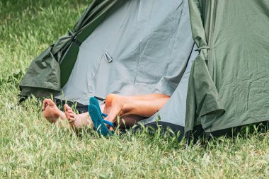Lycian Yolu 'nun oradaki yürüyüş sırasında yeşil çimlere monte edilmiş, kamp çadırında uzanan sevgi dolu bir çift.