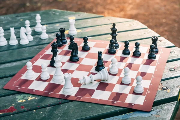 Peças de xadrez em um tabuleiro de xadrez e smartphone o conceito