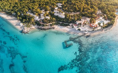 Plajı ve küçük bir tatil köyü oteli olan paradiasal huzurlu sahil manzarası.