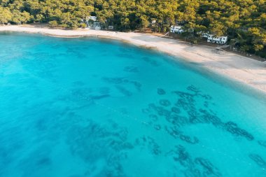 Plajı ve küçük bir tatil köyü oteli olan paradiasal huzurlu sahil manzarası.