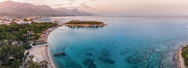 Kemer tatil beldesinin akşam manzarası, Türkiye 'nin nefes kesici hava görüntüsüyle sahili cazibesi manzarasını ve canlı mavi sularını gözler önüne seriyor