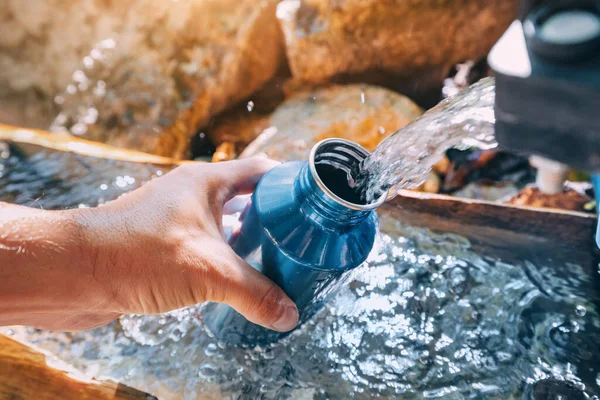露营或远足时从泉水中倒水 干净的水可能被污染 对健康有害 — 图库照片