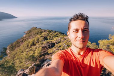 Happy man taking selfie admiring view of a scenic sea coast. Lycian Way travel sights