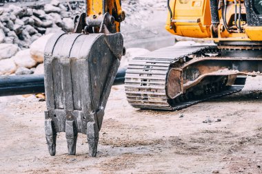 Bir buldozer kürekle yorulmadan çalışır, toprağı hareket ettirir ve bir inşaat alanının gelişimine katkıda bulunur..