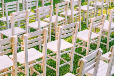 Doğa 'nın Düğün Sahnesi: Güzel bir bahçe düğünü, yeşil arka planda beyaz sandalyeler, zarif bir açık hava kutlamasının özünü yakalar.