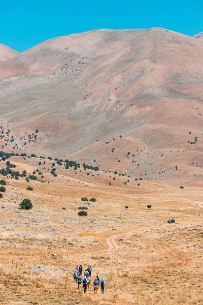 Bir Grup Insan Kurak Çöl Manzarasının Ortasında Görkemli Dağları Güzel — Stok fotoğraf