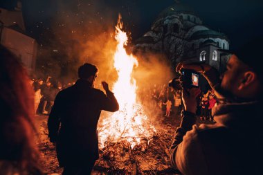 06 Ocak 2024, Belgrad, Sırbistan: Her kesimden insanlar Noel Arifesi Badnjak törenine katılmak için bir araya gelerek, şenlik ateşinin etrafında toplanarak bu neşeli olayı paylaştılar