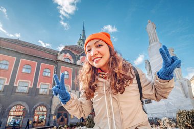 Neşeli genç bir kadın, Sırbistan 'ın Subotica kentini keşfediyor. Enerjisi, tarihi kasaba meydanının hareketli atmosferini artırıyor..