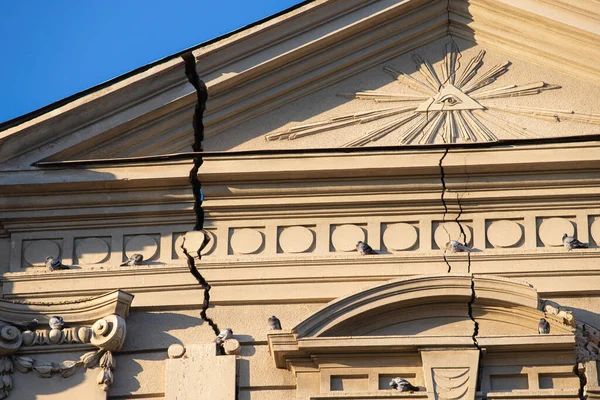 weathered facade of the church bears the scars of time, with cracks and fractures etched into its textured exterior, telling the story of its enduring resilience.