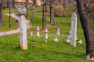 Mezarlıktaki tarihi sütunlar ve Müslüman mezar taşları, Saraybosna bölgesinin çalkantılı geçmişi ve hatırlanmaya duyulan ihtiyacın dokunaklı bir hatırlatıcısı..