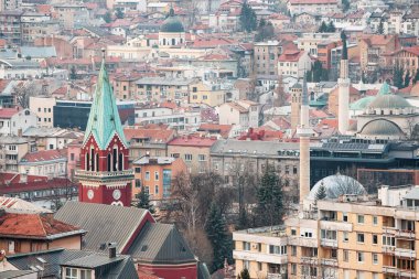 Aziz Anthony Kilisesi 'nin yüksek çan kulesi, Saraybosna' nın ufuk çizgisi arasındaki cennete doğru uzanıyor..