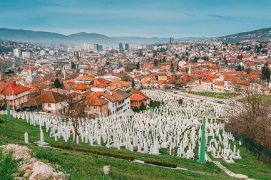 16 Mart 2024 'te Saraybosna, Bosna-Hersek: Saraybosna' nın kasvetli mezarlığı, tepenin üzerindeki beyaz mezar taşlarıyla sessiz bir tanık olarak duruyor.