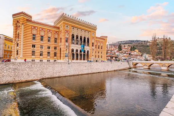 15 Mart 2024, Saraybosna, Bosna-Hersek: Saraybosna 'nın görkemli dağlarıyla birlikte manzarasının güzelliği belediye binasının cephesini çerçeveliyor.