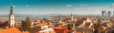 a scenic panoramic observation of Belgrade's cityscape, with its picturesque houses and historic churches lining the banks of the Danube River. clipart