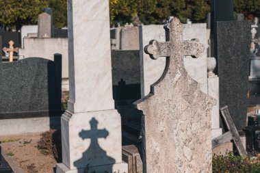 Mezarlığın sessiz sükunetinin ortasında, mezar taşları ve haçlar merhumun anısına dikilmiş, ebedi bir hatıra ve onur sembolü..