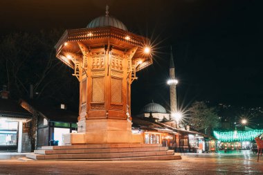 Saraybosna 'nın ikonik Sebilj çeşmesi: Bascarsija' da gece göğüne karşı aydınlatılmış, kentin zengin mirasının bir simgesi