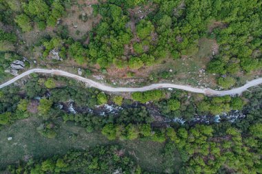 Karadağ 'ın verimli arazisini kesen bir seyahat yolunun insansız hava aracı görüntüsü