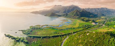 Karadağ 'da gün batımında Skadar Gölü ve çevresindeki tepelerin hava aracı görüntüsü