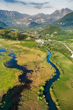 Skadar Gölü kıyısındaki sevimli bir köy olan Virpazar 'ın kuş bakışı manzarası, Karadağ' ı gezmek ve kuşları izlemek için mükemmel.
