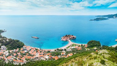 Karadağ 'daki Sveti Stefan yarımadasının manzarası, panoramik deniz manzaralı çarpıcı bir tatil beldesi.