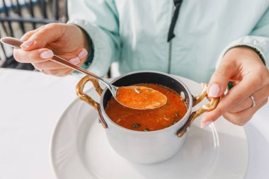 Bir kaşık dolusu lezzetli balık yahnisine batırılmış, bu geleneksel yemeğin ağız sulandırıcı lezzetlerini gözler önüne seren bir kaşık..