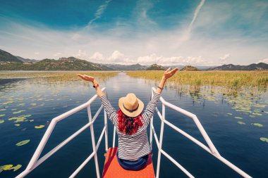 Boş bir yaşam tarzı: Karadağ 'ın Skadar kentinde tekne turunun keyfini çıkaran mutlu bir turist.