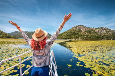 Boş bir yaşam tarzı: Karadağ 'ın Skadar kentinde tekne turunun keyfini çıkaran mutlu bir turist.