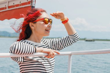 Güneş gözlüklü ve şapkalı neşeli kadın Skadar Gölü 'nün manzarasını keşfediyor..