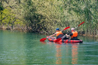 08 Mayıs 2024, Virpazar, Karadağ: Mutlu çift Skadar Gölü 'nde kayak yaparken, doğada yaz tatilinin tadını çıkarıyor.