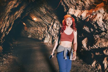 Bir dağ manzarasında manzaralı bir tünelde yürüyüş yapan maceraperest kadın yaz turizminin özünü yakalıyor.