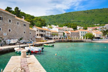 09 Mayıs 2024, Petrovac, Karadağ: Petrovac 'taki Akdeniz kıyılarının yaz panoramasında büyüleyici evler ve berrak mavi sular yer alıyor