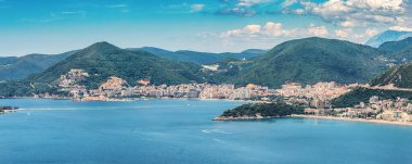 Karadağ 'ın Budva kentinin hava manzarası panoramik kıyı şeridi ve Akdeniz tatil beldesi atmosferini vurguluyor.