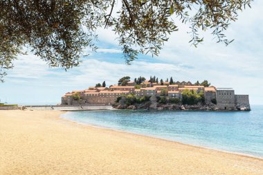Karadağ 'ın Sveti Stefan adasının turkuaz suları ve Balkan cazibesinin bir zeminine karşı manzaralı kıyı şeridiyle sahip olduğu lüksü keşfedin.