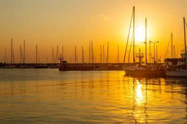 27 Ağustos 2022. Yelkenliler Hel Limanı 'na demir attı. Batan güneşin ışığında siluetler Hel, Hel Yarımadası, Baltık Denizi, Pomerania, Polonya  