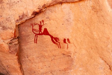 Neolithic rock art. Rock painting of a camel with rider. Tadrart Rouge. Tassili N'Ajjer National Park. Sahara Algerian Desert. Illizi Province, Djanet, Algeria, Africa    