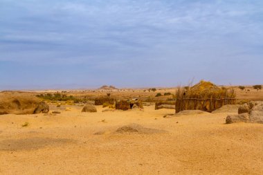 Tuareg kampı çölde. Yuvarlak kulübeler geleneksel bir kamışla yapıldı. Cezayir 'in güneyi, Illizi Eyaleti, Djanet, Cezayir, Afrika   