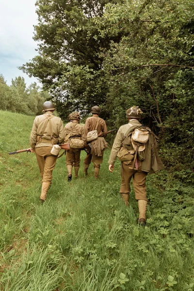 二战期间 历史上的后来者身着美国步兵的服装在森林里巡逻 从后面看 波兰波尔布卡 — 图库照片