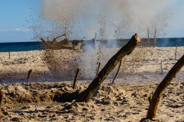 Background. Bombs exploding on the beach. Reconstruction of battle from the Second World War.  clipart