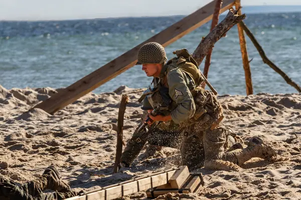 历史重建 一名二战的美国陆军步兵在海滩上作战 免版税图库照片