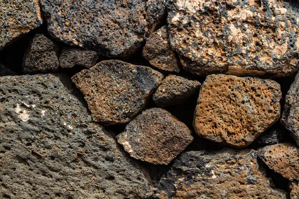 stock image Close-up. Background. Wall of large and small natural volcanic stones.