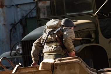 Bir 2. Dünya Savaşı piyade tümeni askeri şehir çatışması sırasında araçlar arasında koşar.