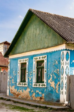 Tipik bir Ukrayna kır evi. Dekoratif köşeli ve pencere çerçeveli harap olmuş eski renkli bir ev. Doğu Ukrayna.