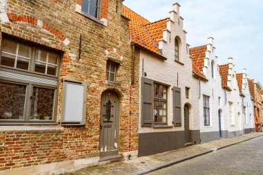 Bruges caddesinde. Piramit cephesi ve kaldırım taşlarıyla döşenmiş tipik renkli evler. Bruges, Belçika, Avrupa