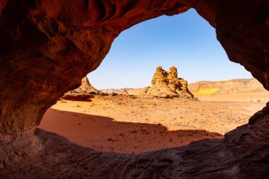 A view of the beautiful rock formations through an erosional stone window in the rock. Tassili n'Ajjer National Park, Algeria, Africa clipart